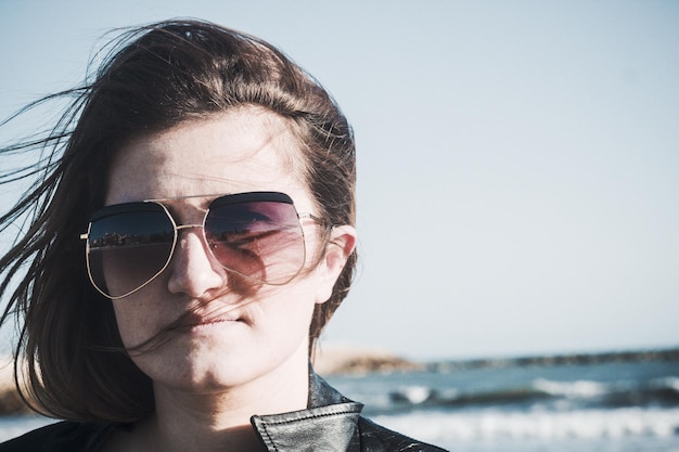 Close-up van een jonge vrouw met een zonnebril op een zonnige dag