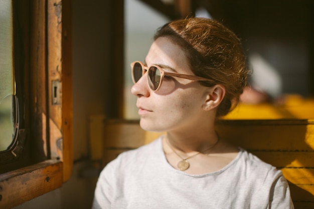Close-up van een jonge vrouw met een zonnebril thuis