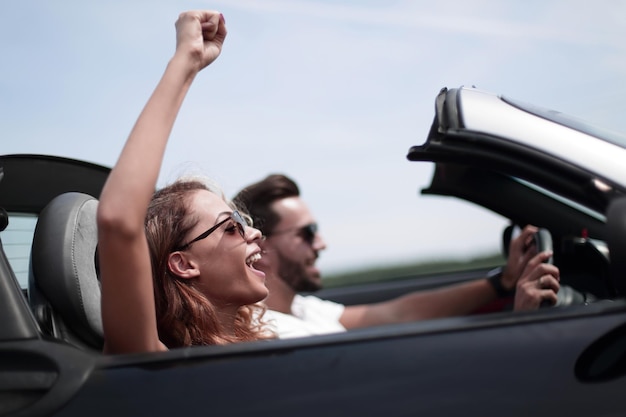 Foto close-up van een jonge vrouw met haar vriendje in een cabriolet