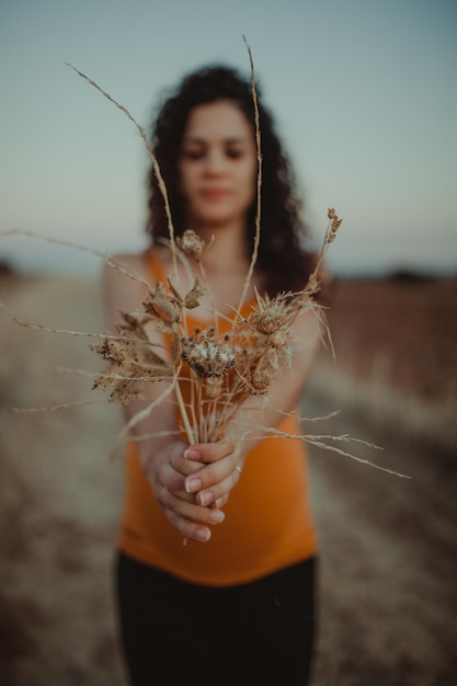 Close-up van een jonge vrouw met planten tegen de lucht