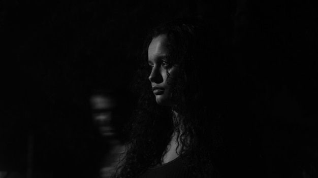 Foto close-up van een jonge vrouw tegen een zwarte achtergrond