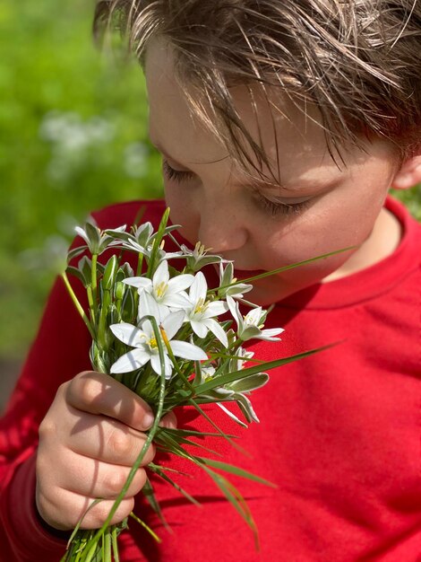 Foto close-up van een jongen die bloemen ruikt