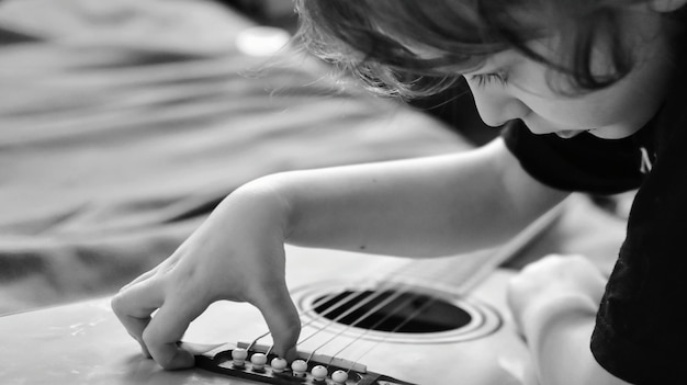 Foto close-up van een jongen die gitaar speelt