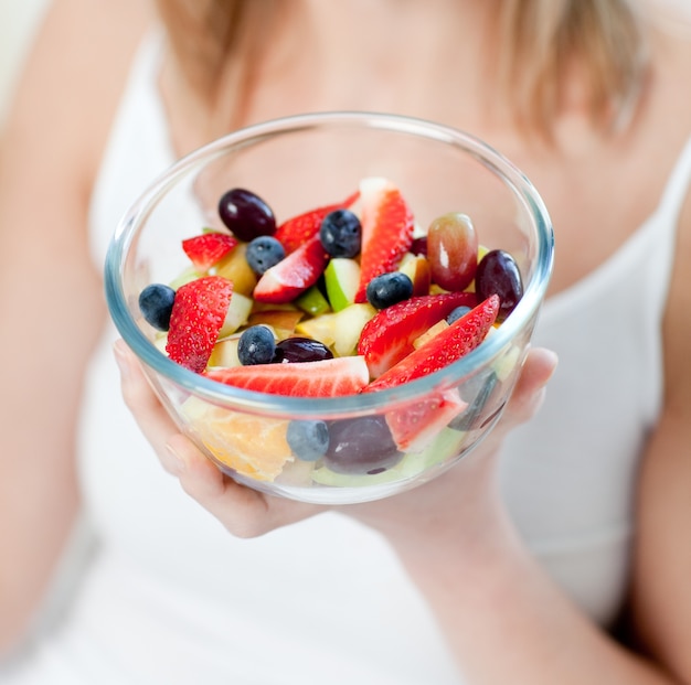 Close-up van een Kaukasische vrouw die een fruitsalade eet