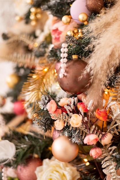 Close-up van een kerstboom versierd met roze bloemen en gouden ballen