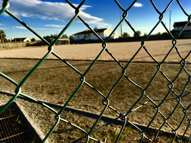 Foto close-up van een kettinghek op het veld tegen de lucht