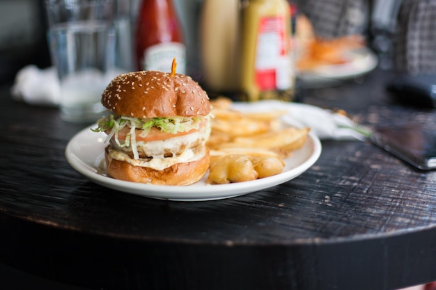 Close-up van een kippenburger met friet op het bord
