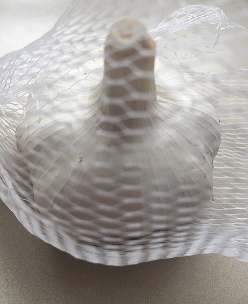 Foto close-up van een knoflookbol in een net op tafel