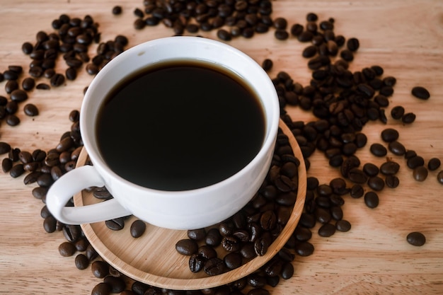 Foto close-up van een koffiekop en bonen op tafel