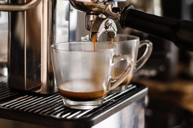 Close-up van een koffiezetmachine die koffie in een kopje giet
