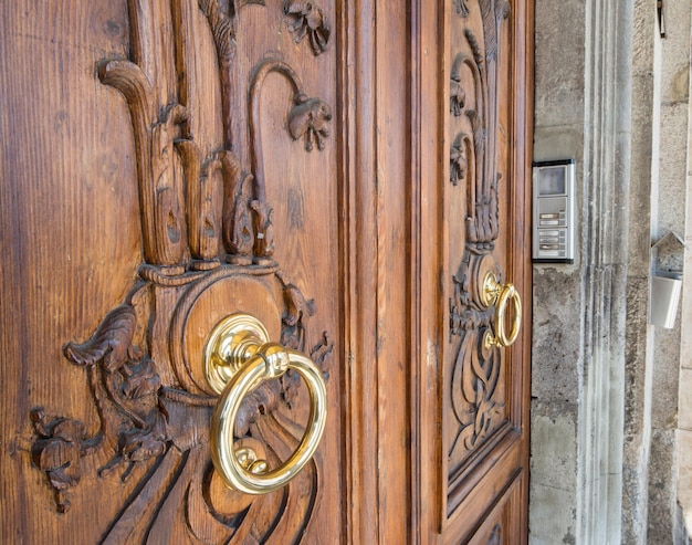 Close up van een koperen klopper in een houten deur