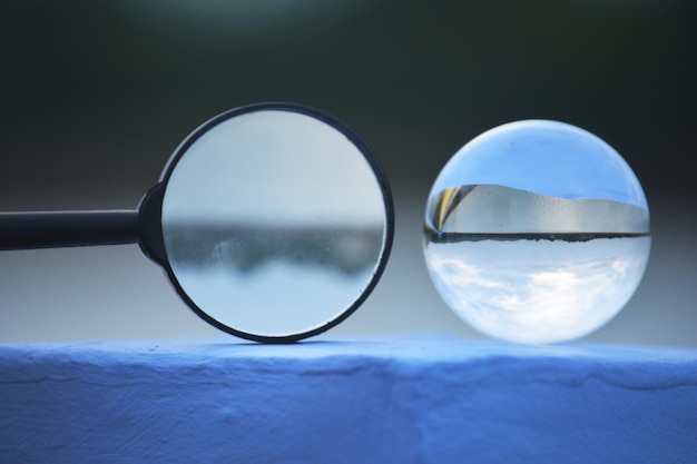 Foto close-up van een kristallen bol en een vergrootglas op een steunmuur