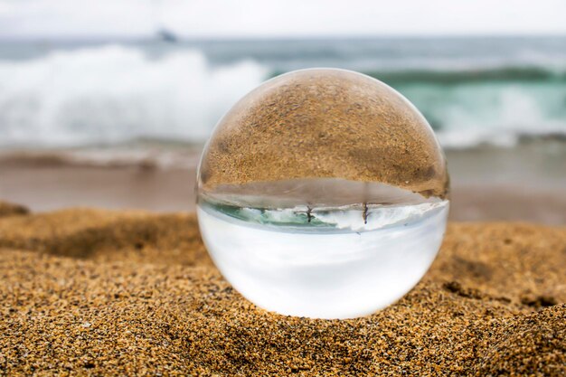 Foto close-up van een kristallen bol op het strand