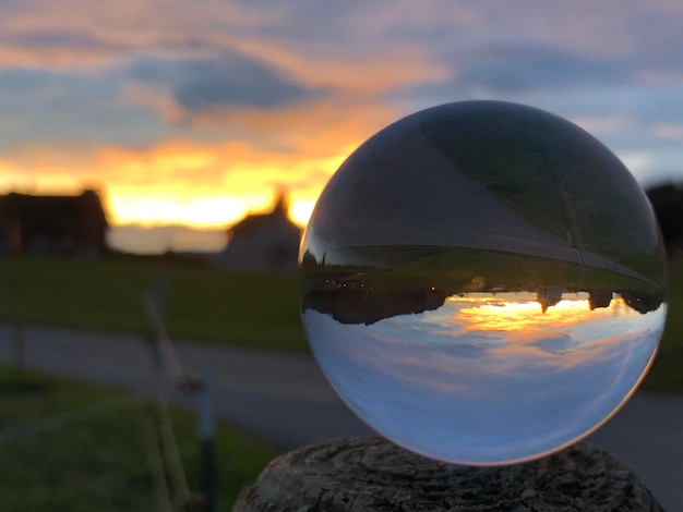 Foto close-up van een kristallen bol op water tegen de hemel tijdens zonsondergang