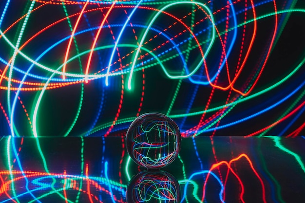 Foto close-up van een kristallen bol tegen verlichte lichten in een donkere kamer