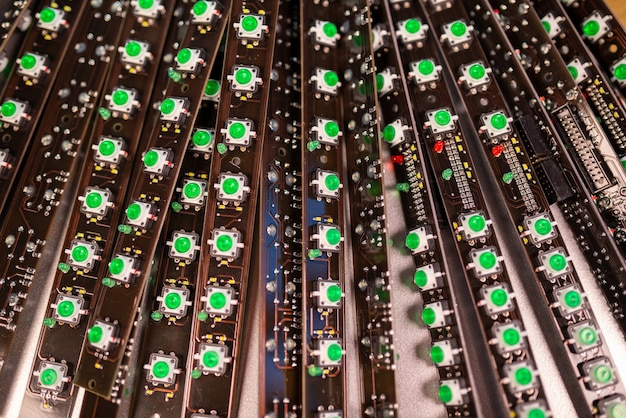 Close-up van een LED-paneel van groene lichtindicatoren is in productie. Het concept van industriële productie van uitrusting voor militaire en strategische doeleinden