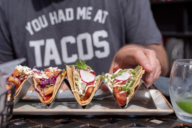 Foto close-up van een man die buiten taco's eet in de zomer