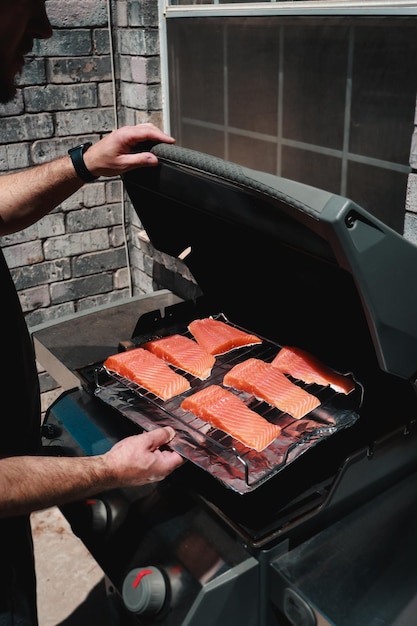 close-up van een man die buiten verse zalm aan het barbecueën is