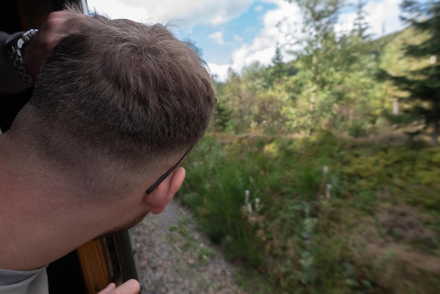 Foto close-up van een man die door het treinvenster kijkt