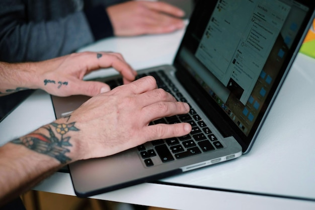 Foto close-up van een man die een laptop gebruikt op kantoor