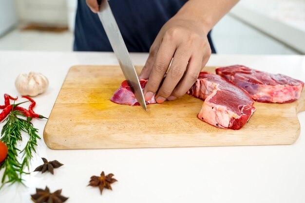 Close-up van een man die eten bereidt op een snijplank