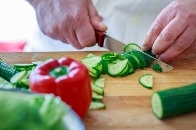 Close-up van een man die eten bereidt op een snijplank