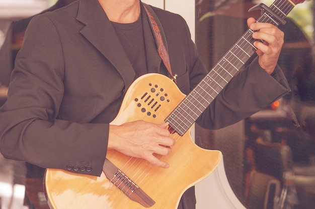 Close-up van een man die gitaar speelt.