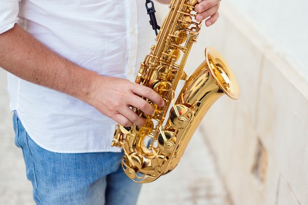 Close up van een man die hartstochtelijk zijn saxofoon op straat speelt