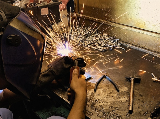 Close-up van een man die in een werkplaats werkt