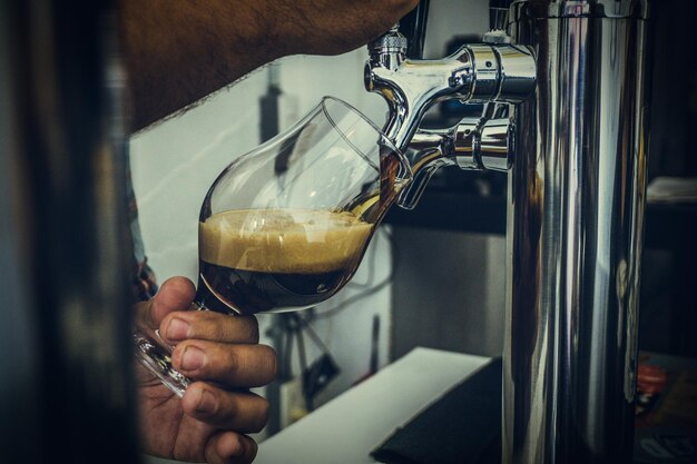 Foto close-up van een man die koffie in een glas giet