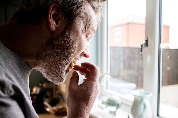 Close-up van een man die thuis eet.