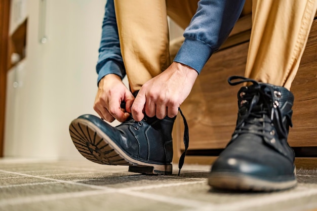 Close-up van een man die thuis zijn veters aan schoenen knoopt