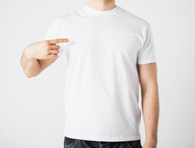 close-up van een man in een leeg t-shirt die naar zichzelf wijst