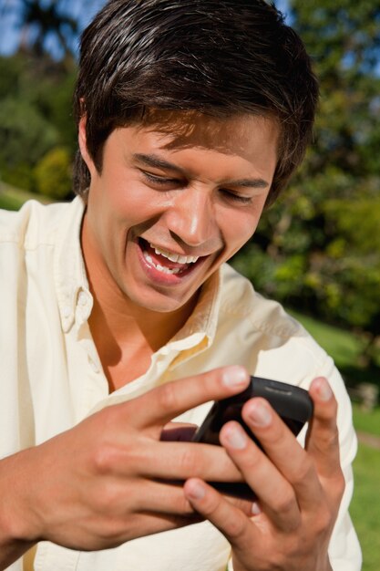 Close-up van een man met behulp van een telefoon terwijl hij zit