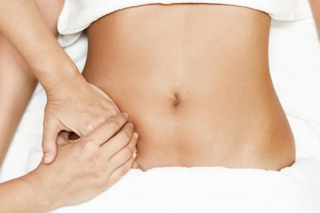 Close-up van een masseur die een vrouw massageert in een spa.