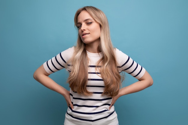 Close-up van een meisje in casual kleding haar lip bijten op een blauwe geïsoleerde achtergrond