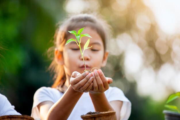 Close-up van een meisje met een plant in de hand buiten