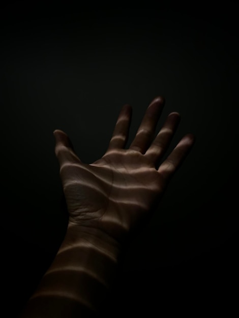 Close-up van een menselijke hand op een zwarte achtergrond