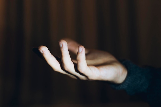 Close-up van een menselijke hand op een zwarte achtergrond