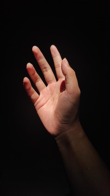 Close-up van een menselijke hand op een zwarte achtergrond