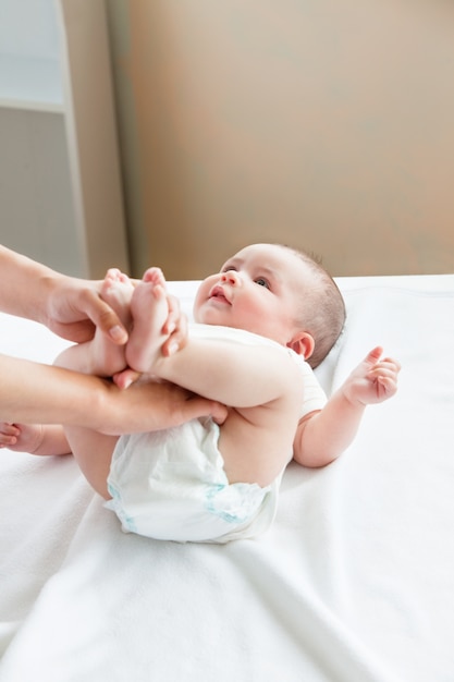 Close-up van een moeder die de luier van haar baby verandert