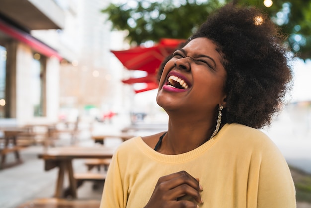 Close-up van een mooie afro-amerikaanse latijnse vrouw die en aardige tijd glimlacht doorbrengt bij de koffiewinkel.