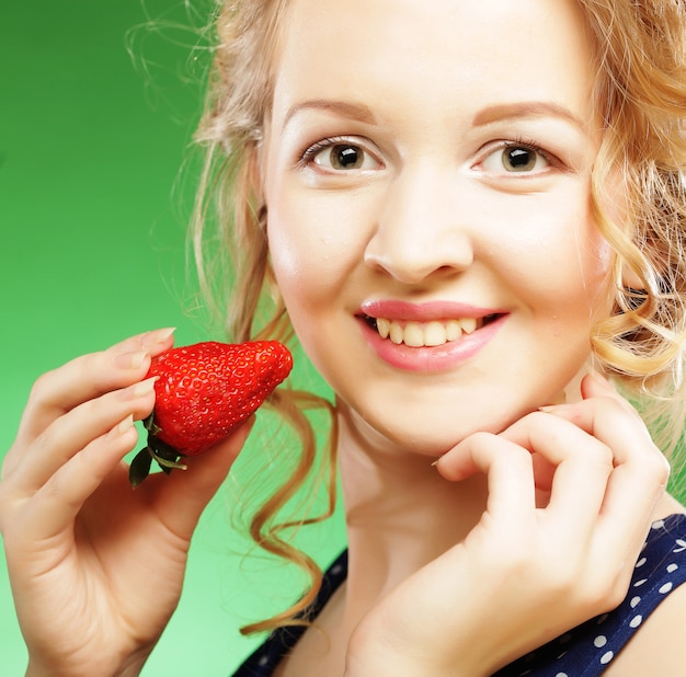 Close-up van een mooie blonde holding een aardbei