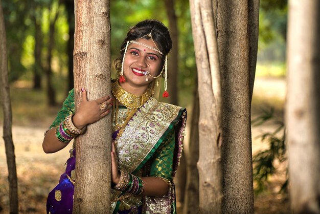 Close-up van een mooie Indiase bruid in een traditionele saree die buiten in het park poseert