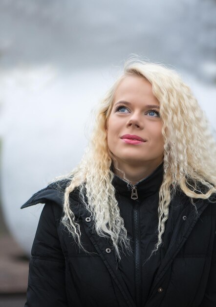 Foto close-up van een mooie jonge vrouw die in de winter naar boven kijkt