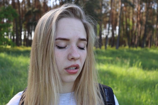Foto close-up van een mooie jonge vrouw met gesloten ogen die in het bos staat