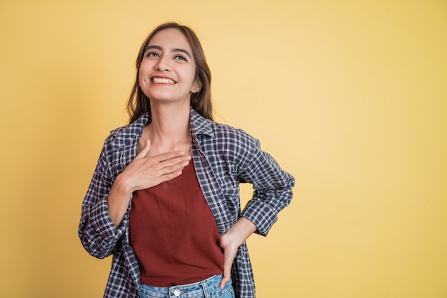 Close-up van een mooie vrouw die lacht met de handen voor de borst met een kalme uitdrukking met copyspace