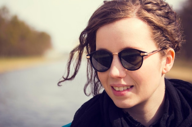 Close-up van een mooie vrouw met een zwarte zonnebril op een zonnige dag