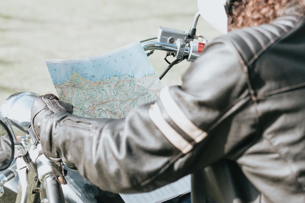 Close up van een motorrijder die een kaart controleert tijdens een reis. Motor reizen concept.