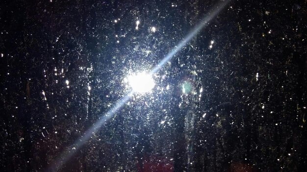 Foto close-up van een nat glasvenster tegen verlichte verlichtingsapparatuur tijdens de moesson